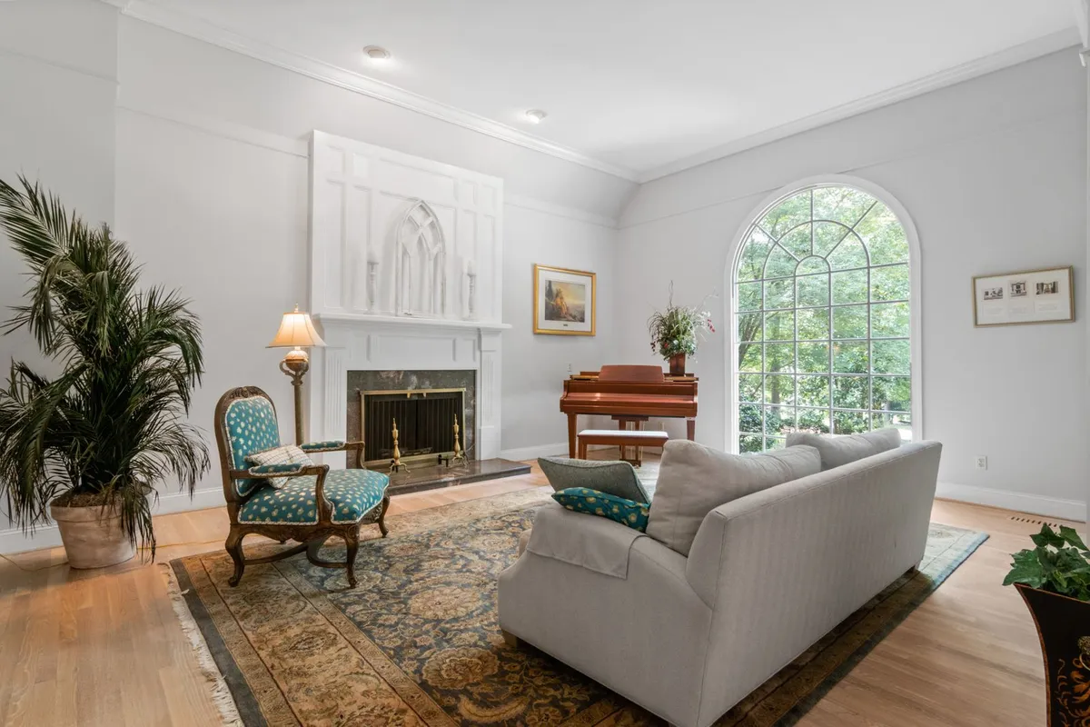 A living room with a light plank floor around a large area rug — flooring is priced on the full measured floor area, including the part a rug will spend its life covering.