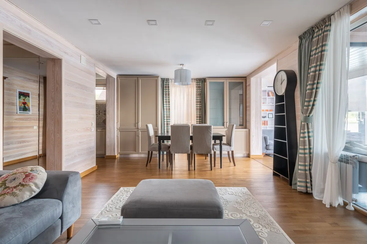 An open-plan living and dining area on a warm plank floor — the planks themselves are 40–55% of a bamboo flooring budget, so the construction type chosen for a run like this sets most of the project total.