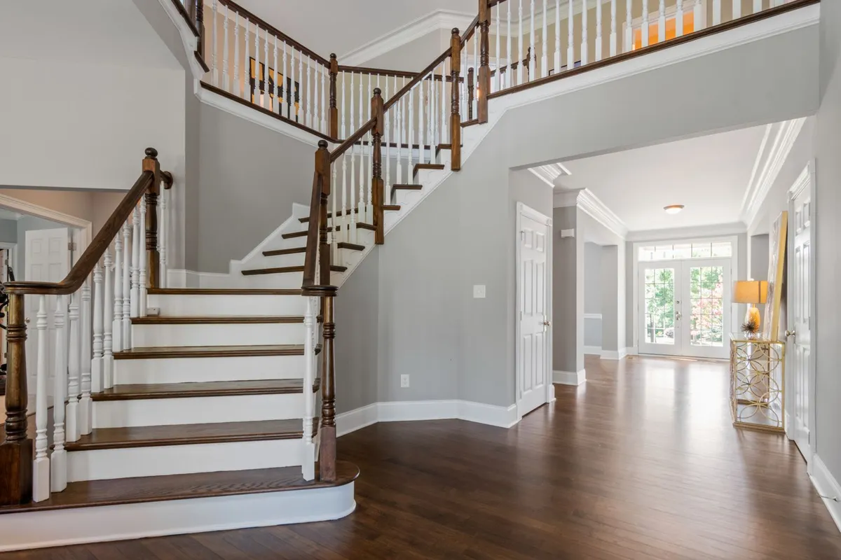 Stair walls and long halls are where the footage adds up — and where Angi's note that pros give about $0.50 per linear foot back on larger projects starts to matter
