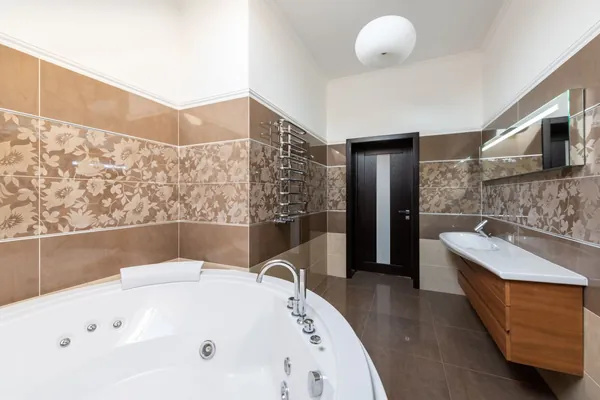 Finished modern bathroom with a freestanding tub, wooden vanity and patterned tile floor