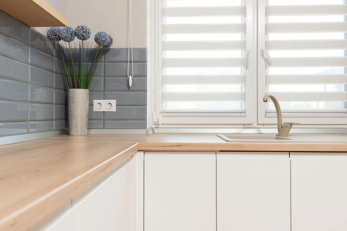 A light wood countertop with its sink cut out, under a window — cutouts, edge work and the first sealing are 5–10% of a butcher block budget, and the sink cutout is the area that most needs that sealing.