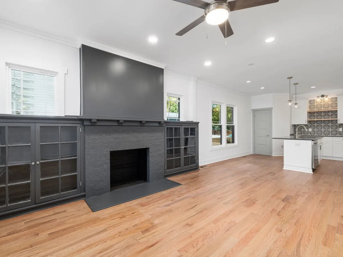 Open-plan living room with a ceiling fan and light kit
