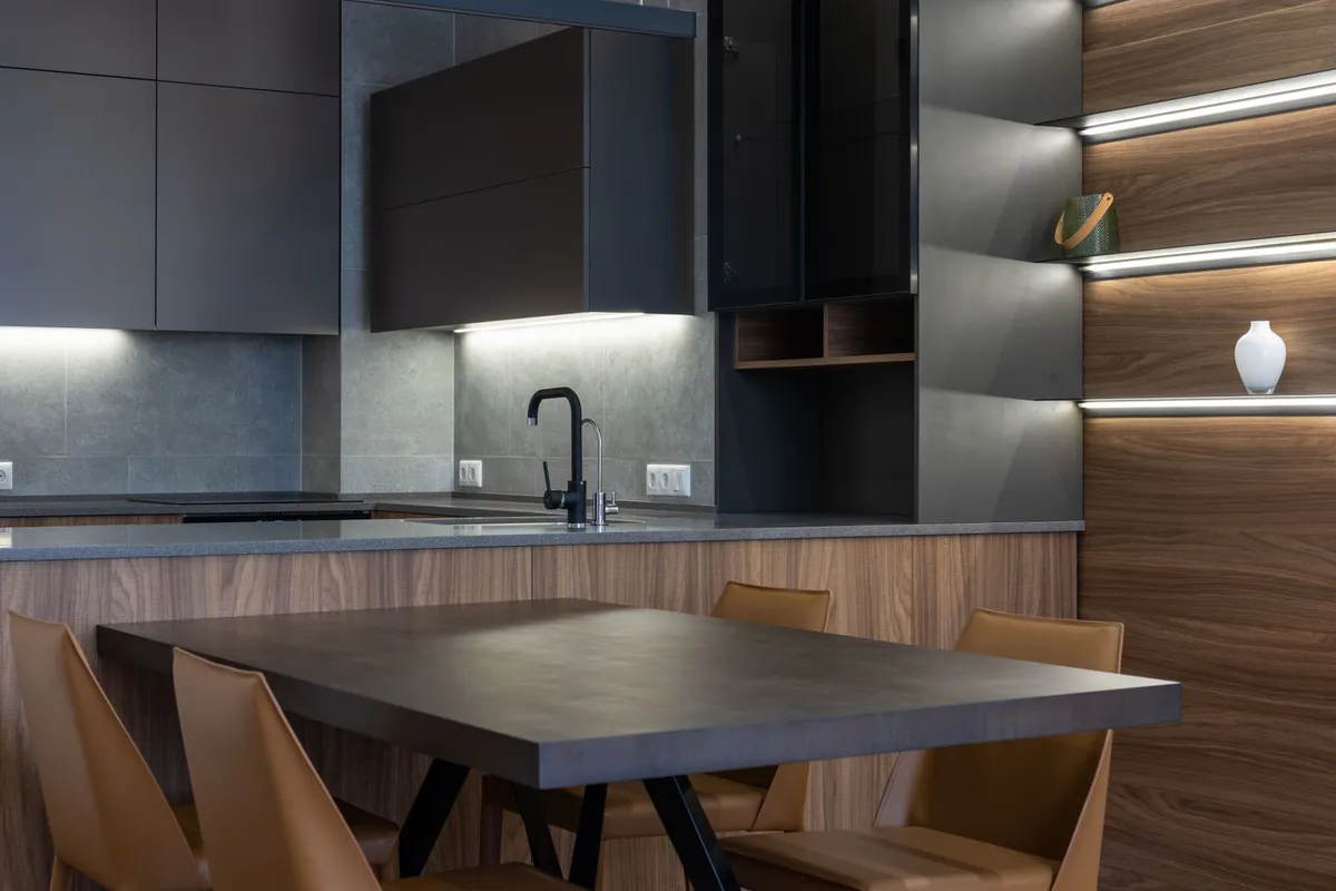 A dark modern kitchen with a matte grey counter run — labour is 70–85% of a concrete counter budget, because the counter is cast and finished as a piece of work, not cut from a stocked slab.