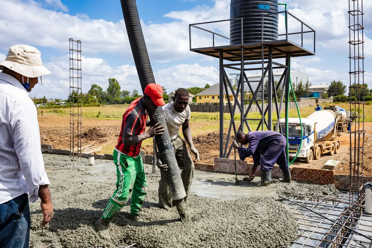 Workers guiding a pump hose as fresh concrete is placed and levelled — when a project needs a new slab rather than polishing the one it has, the pour is a separate project, priced before any polishing figure on this page applies.