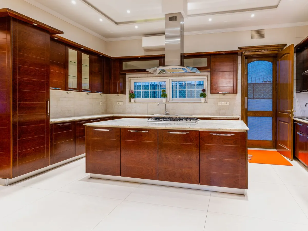 Kitchen with dark wood cabinets and a light marble countertop island