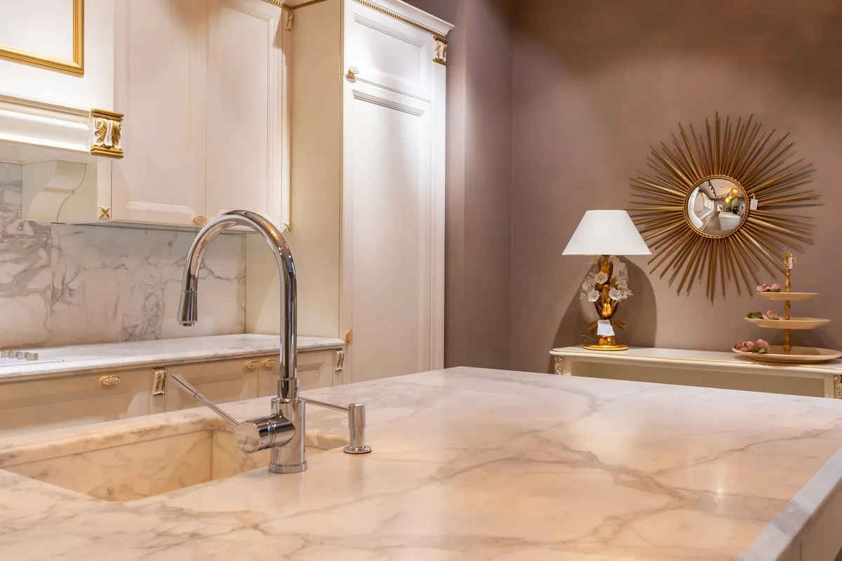 A marble countertop with an integrated sink and chrome faucet — sink cutouts and edge work are fabrication, 20–30% of a typical countertop budget, priced in the shop before the slab ever reaches your kitchen.
