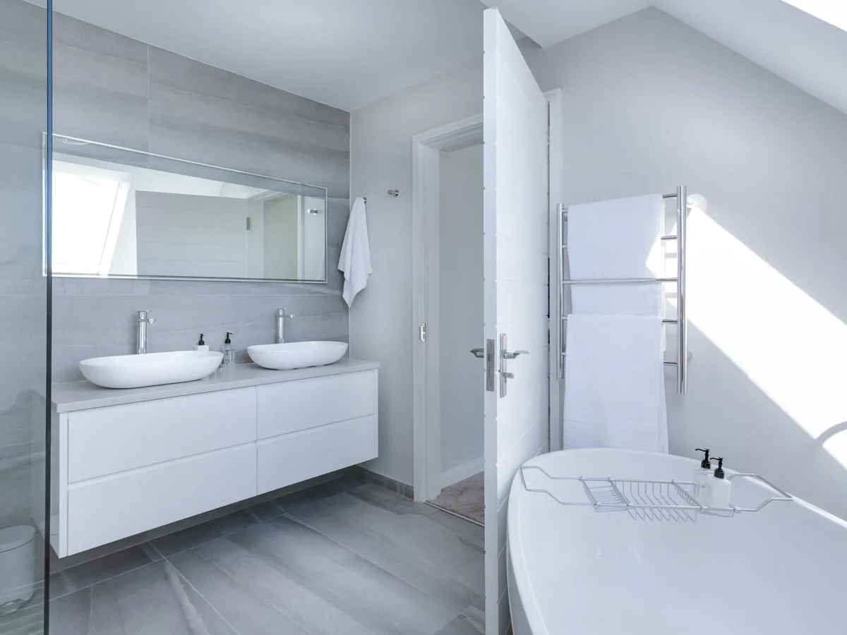 Bright bathroom with a white double vanity, a light counter and two vessel bowls