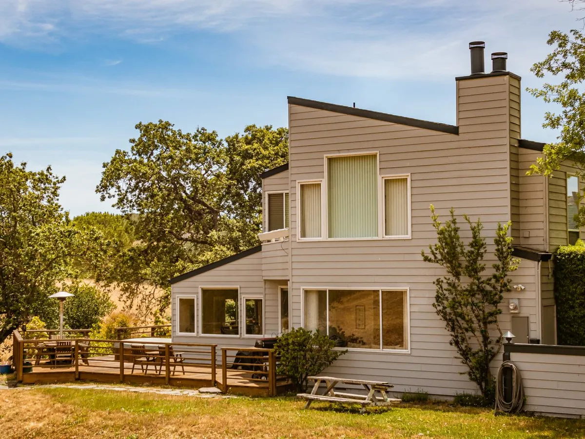 House with a spacious wooden deck and railing in the backyard