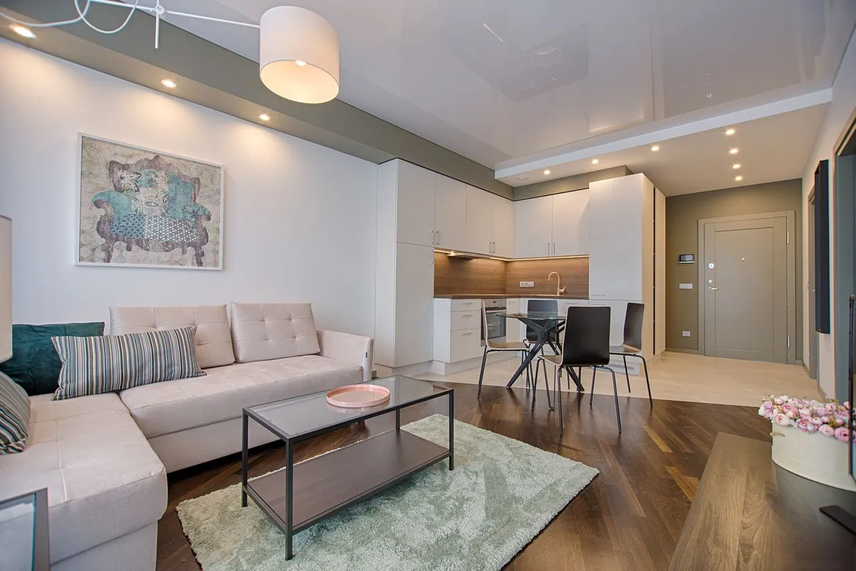 An open-plan living area with a dark wood plank floor — plank width, species and finish are the choices written into a floor like this, and they are what move the material line inside the per-square-foot band.