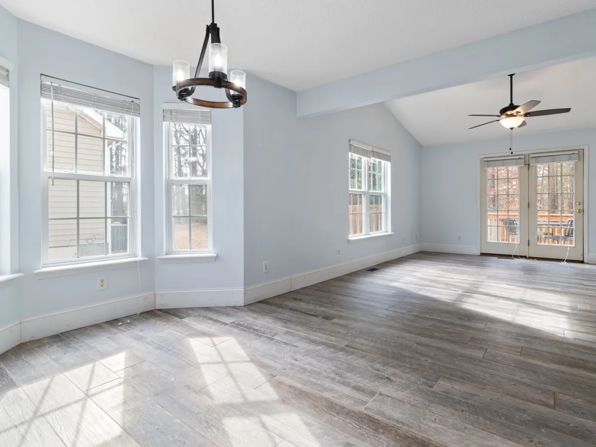 Bright living room with a newly installed wood plank floor and large windows