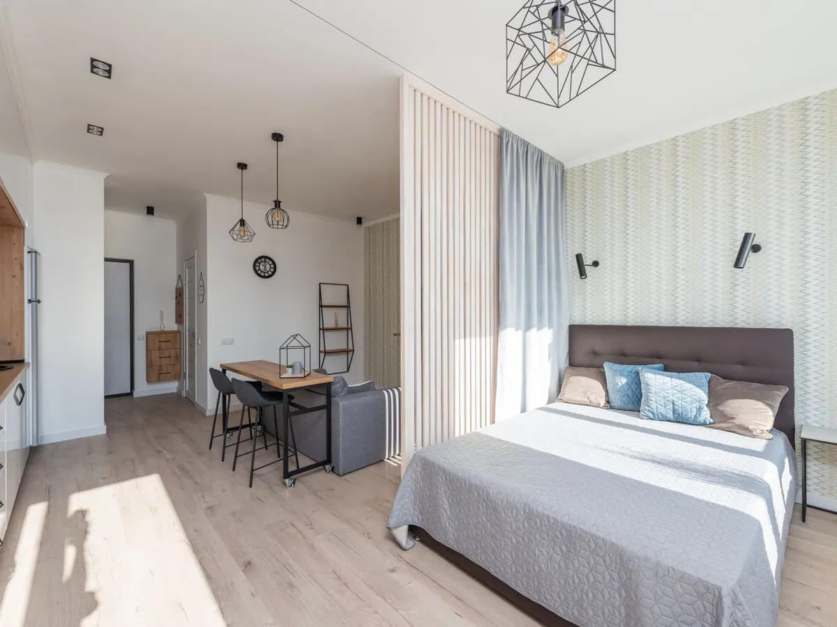 Finished studio unit with a bed, dining area and kitchen fitted into one converted space
