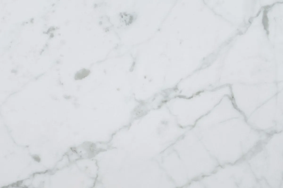 A white veined stone surface in close view — veining and colour decide the slab grade, and grade is the single biggest step between the tiers on this page.