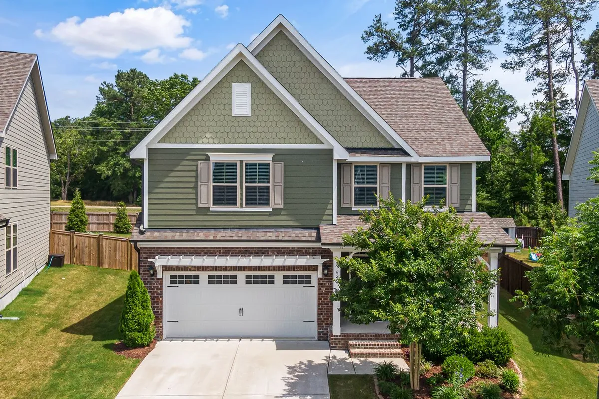 A two-story house with several gables and roof levels — height and roof complexity add $1–$3 per linear foot in the guides, and a roofline like this carries more corners, miters and downspouts than a simple rectangle.