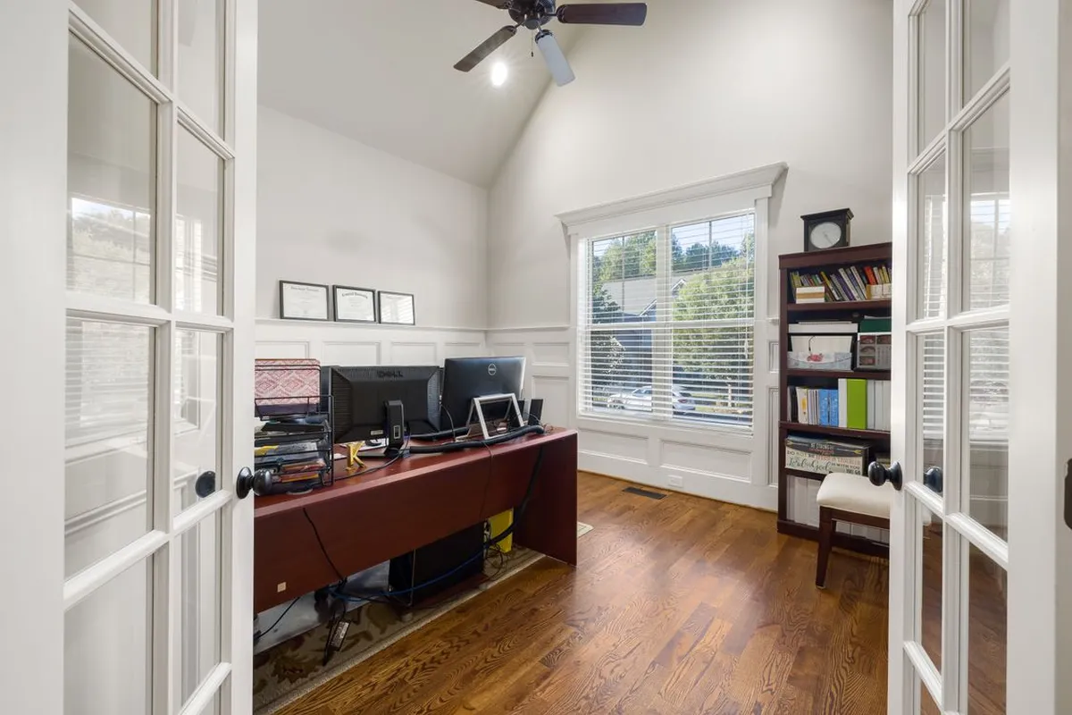 A home office on a wood floor — refinishing is a labor project: the sanding, staining and finishing crew is 70–80% of a typical refinishing budget, which is why the same floor prices by the method chosen, not by new material.