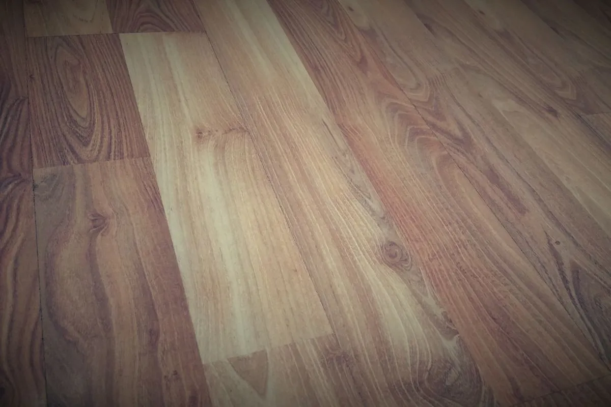 Hardwood planks in close view, showing grain and colour variation between boards — species and grade are written into grain like this, and they are what move the material line.