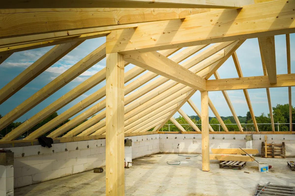 New roof framing and rafters over a framed addition — roof structure and tie-in to the existing house are a major part of the shell cost.