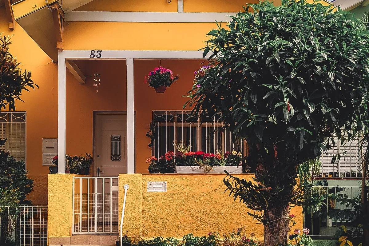 A house painted in a bold yellow with white trim — a strong color change like this commonly needs primer or an extra coat over the old color, which is paint and labor on every wall.