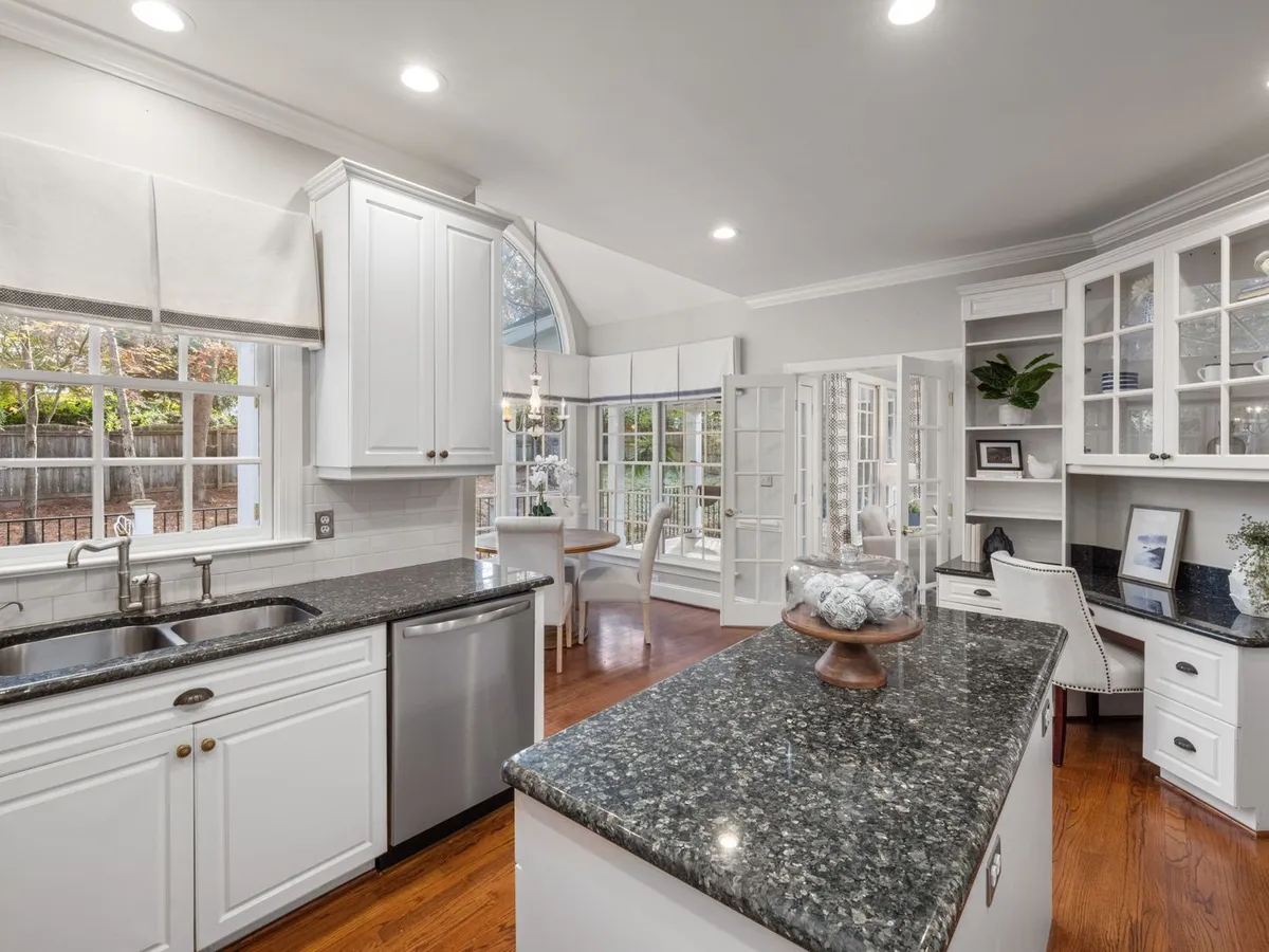 White kitchen with a double sink and a high-arc faucet under a window