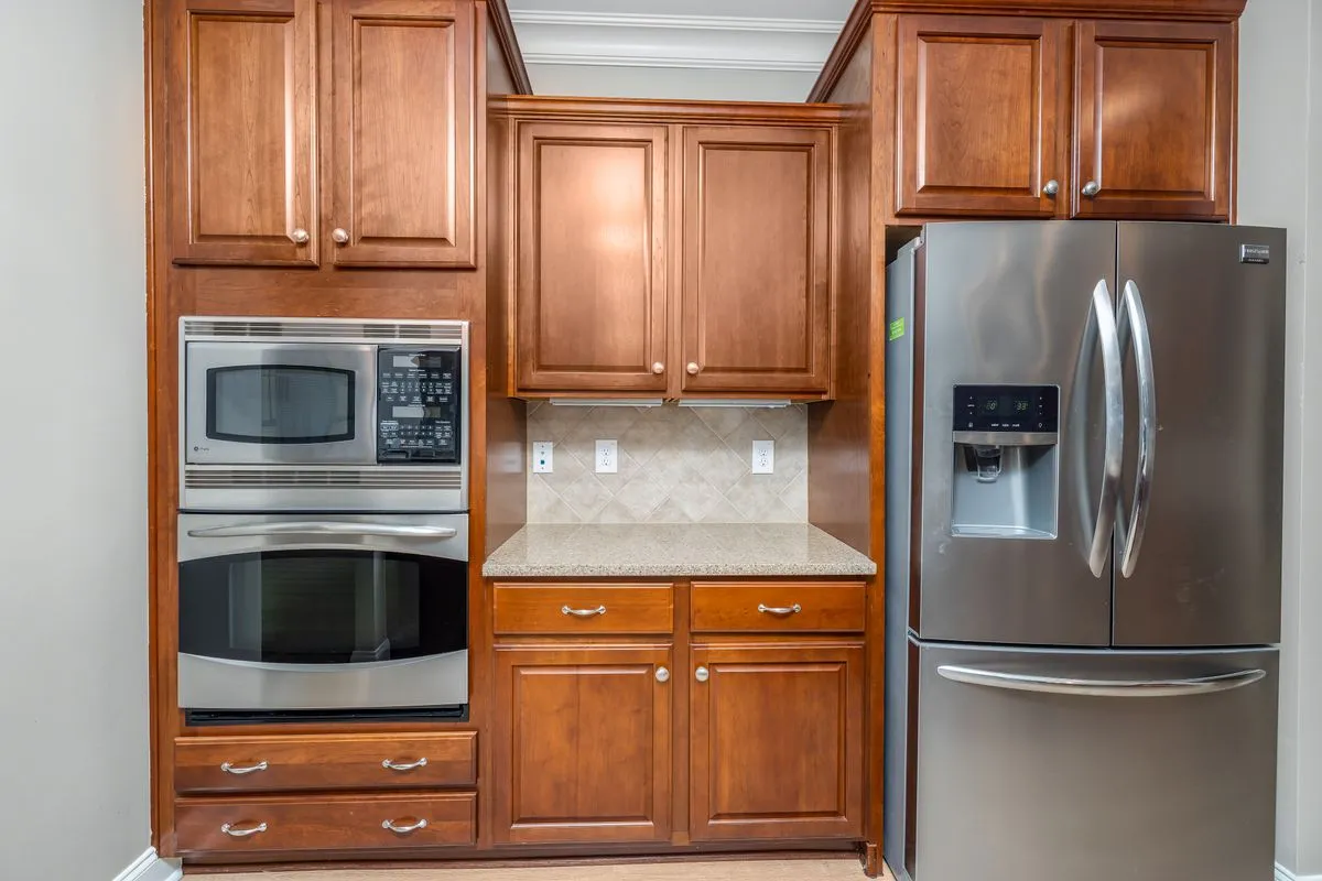 A speckled counter section between wood cabinets in close view — edges and cutouts are where laminate quotes separate: a square edge is free in both guides, upgraded edges run $5–$30 per linear foot.