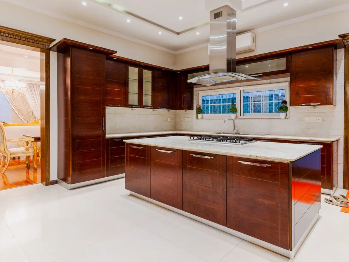 Large kitchen with dark wood cabinets and a light island counter