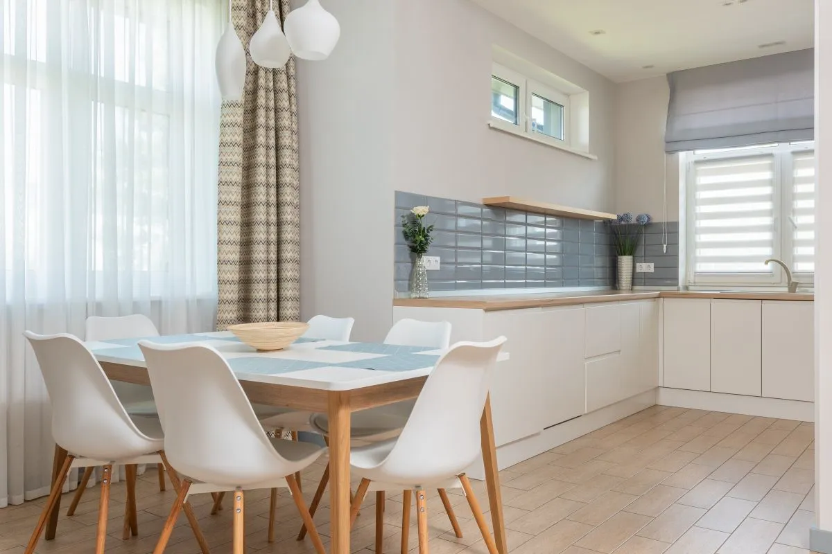 A kitchen counter run in a light wood look along a tiled wall — wood and stone looks are laminate's home ground, printed on the sheet at standard-grade material prices of $10–$18 per sq ft in Angi. Captions describe the visible counters; the pictured counters are not certified as laminate.