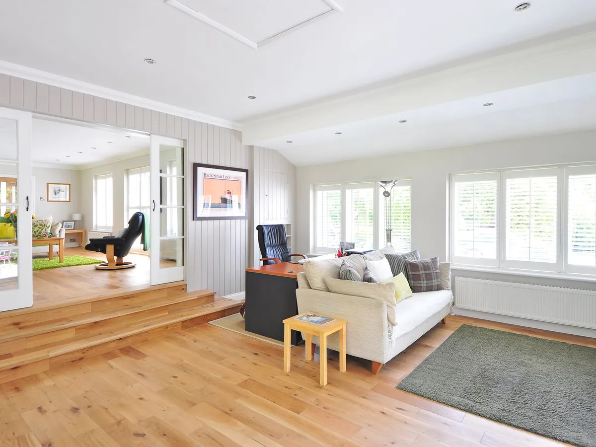 Bright living room with a light wood-look laminate plank floor and large windows