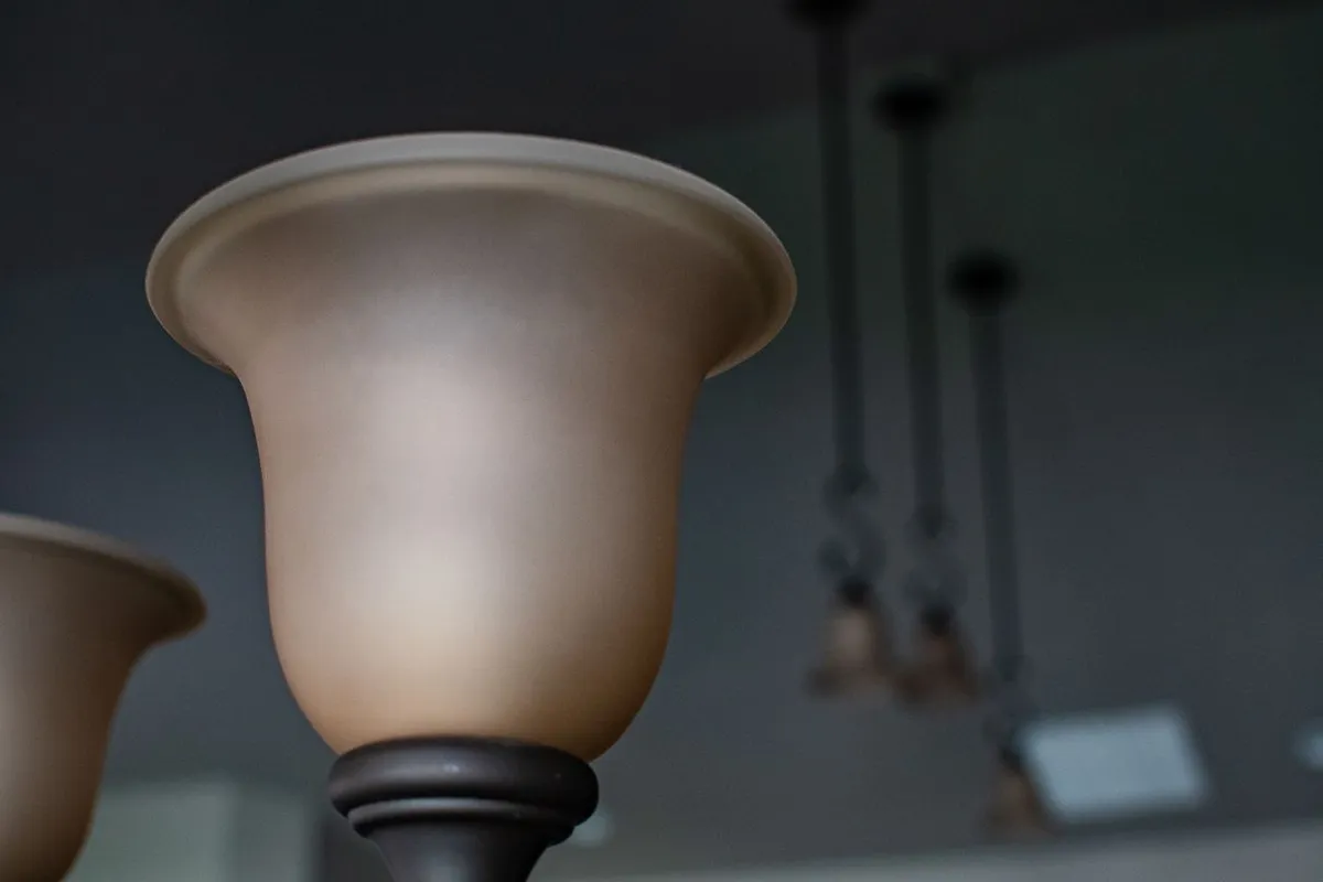 The shade is the cheap part; the box behind it decides the quote — HomeGuide prices labor at $50–$250 per fixture on existing wiring and $250–$600 where new wiring is needed