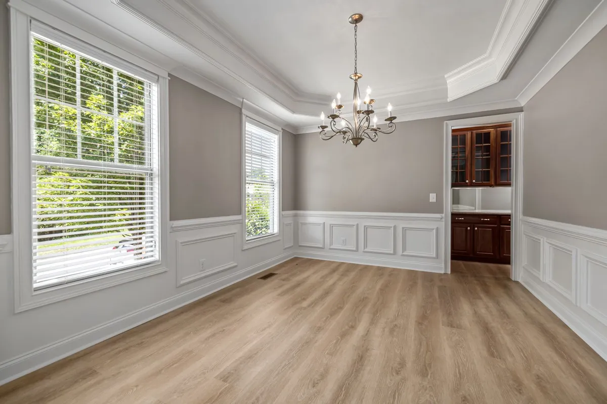 An empty room with wainscoted walls and a light plank floor — thin sheet linoleum telegraphs every flaw in the surface beneath it, which is why subfloor preparation sits in the breakdown above as its own line.