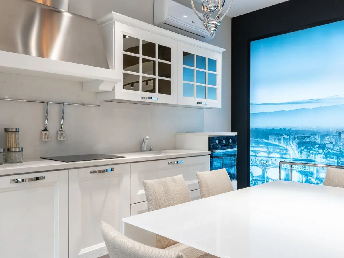 White kitchen with a smooth white countertop run and matching splashback panel