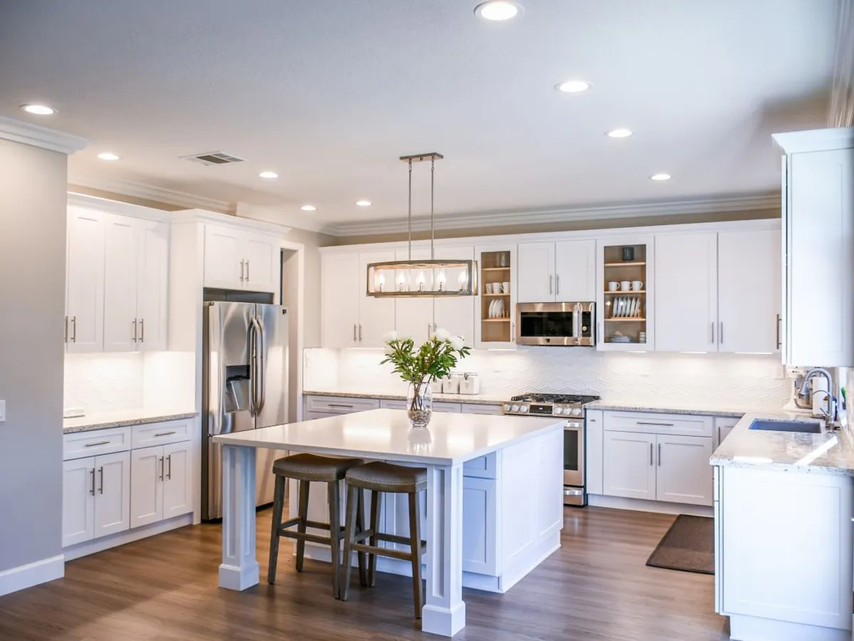 White kitchen with a large island topped with a smooth white stone-look counter