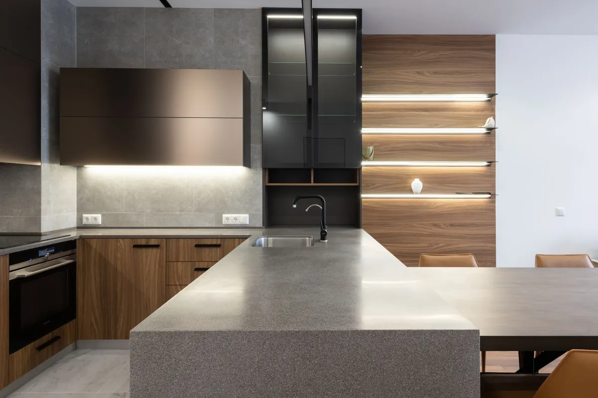 A gray speckled stone island with a waterfall end and an undermount sink — waterfall sides and sink cutouts are fabrication work, and the slab with its fabrication is 60–75% of a quartzite budget.