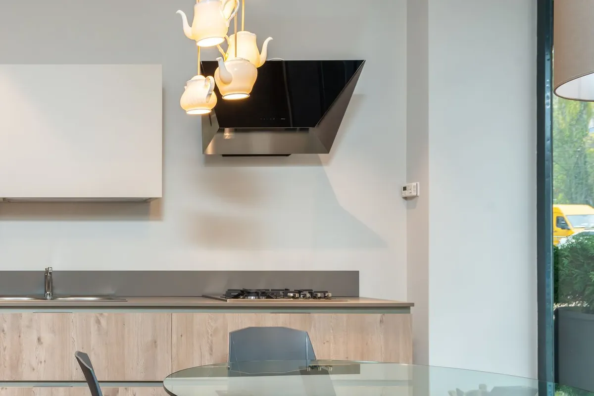 Angled glass hoods price with the wall-mount family — Fixr puts wall-mount units at $200–$500, with island and downdraft models in the tiers above