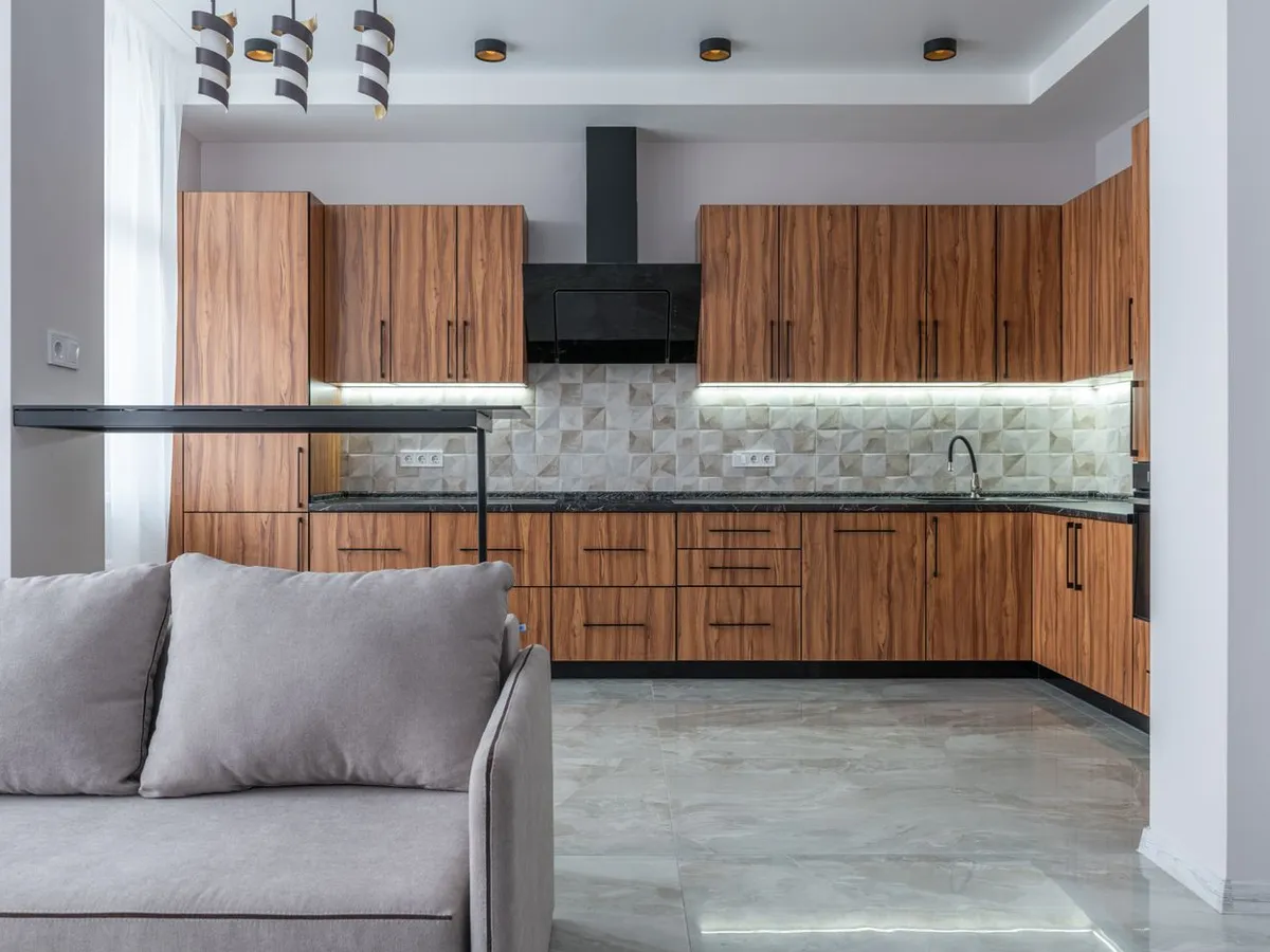 Kitchen with wood cabinets and a black wall-mounted chimney range hood