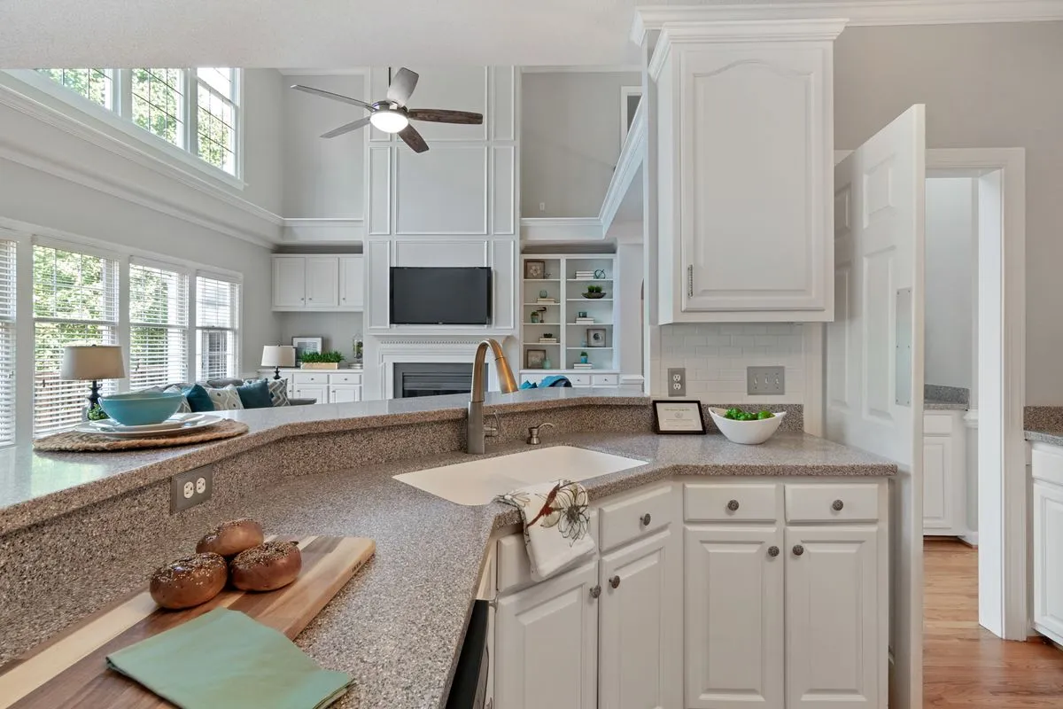 A curved speckled counter run with an undermount sink — colour and brand are the recycled-glass ladder: budget crushed-glass brands sit at the bottom of the guides' bands and handmade slabs at the top.