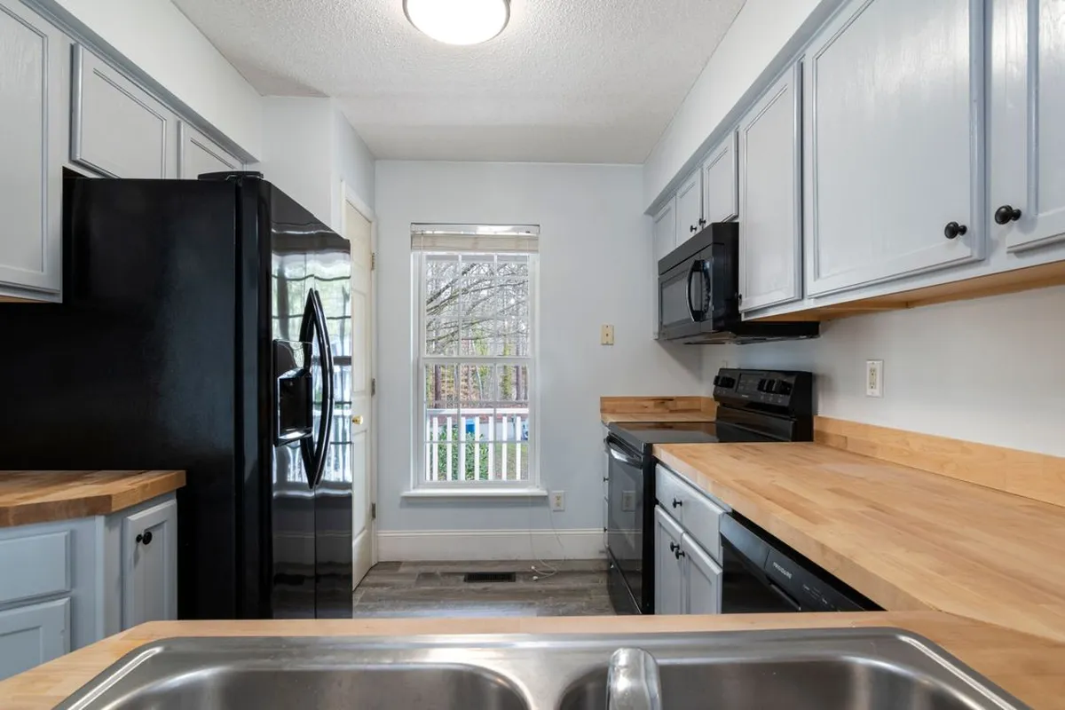 A galley kitchen on a wood-look floor — kitchens are a natural sheet vinyl room because a single sheet has no seams for water to find, provided the subfloor beneath it was levelled first.