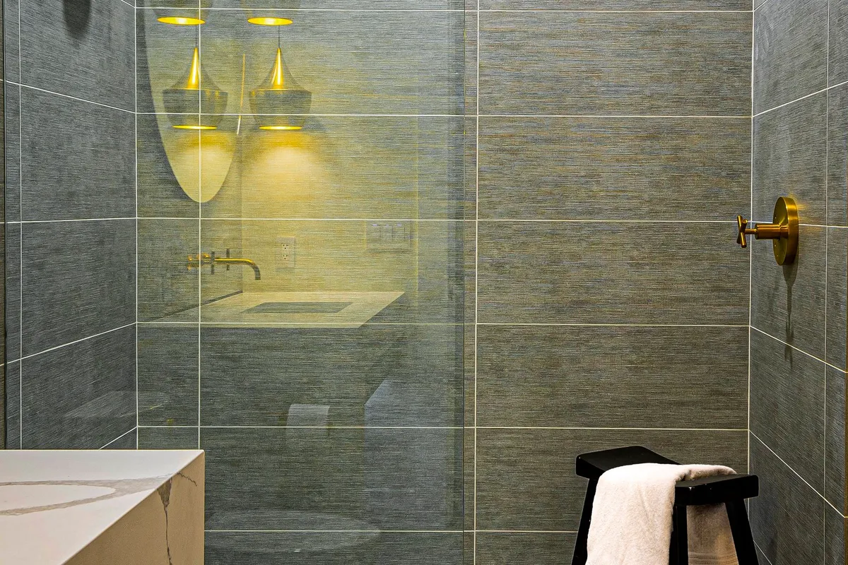 A glass-enclosed shower with modern fixtures — frameless glass and full-height tile are the upgrades that most often move a shower from a refresh into a full rebuild.