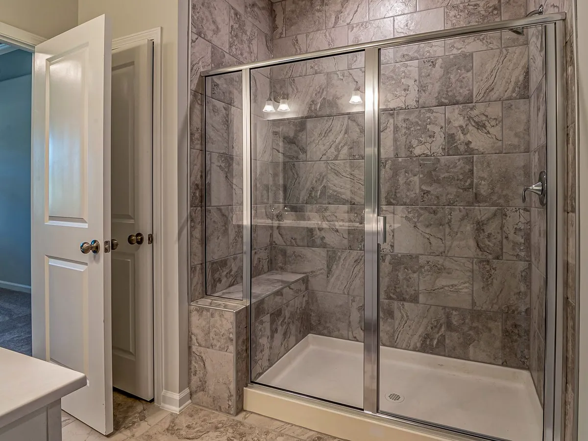 Modern bathroom with a marble tiled shower and sleek glass doors