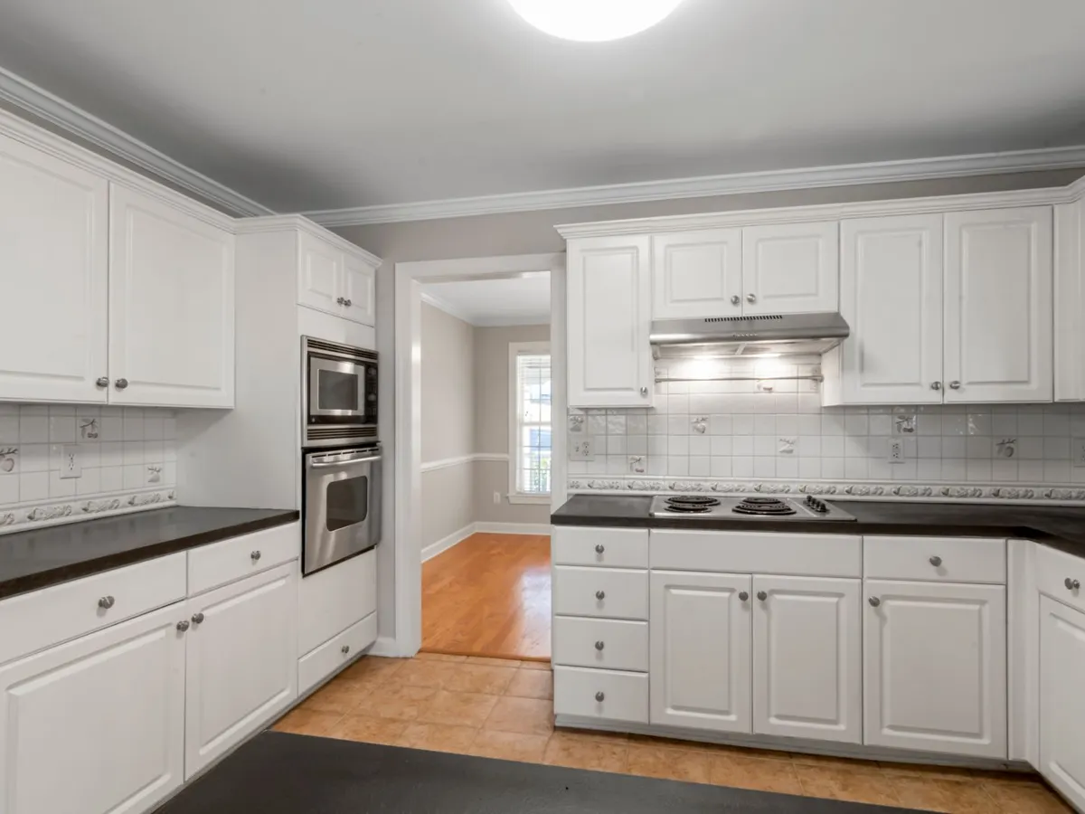 White kitchen with dark matte stone countertops running along both walls