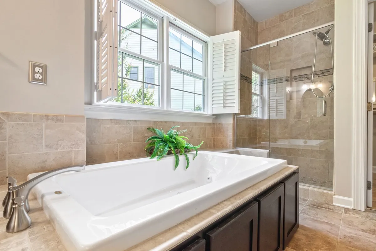 The same stone-look tile carried across a bathroom floor and into the shower — slate is priced by the square foot of tile set, so a floor-and-shower scope is measured as one surface total, not two projects.