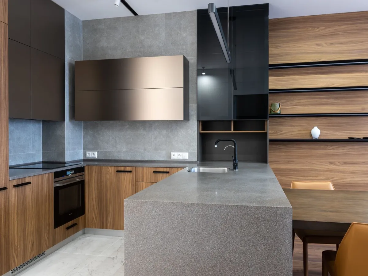 Modern kitchen with a stone island counter and dark cabinet fronts
