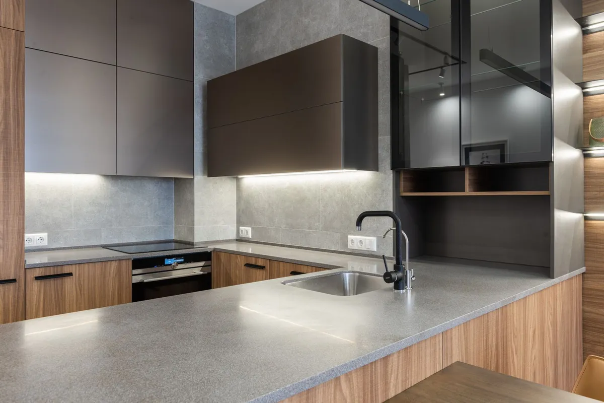 A stone counter run with an undermount sink in close view — the slab and its fabrication are 55–70% of a soapstone budget, and the sink cutout and edge profile you can see here are part of that fabrication work, priced in the shop before the stone reaches the house.