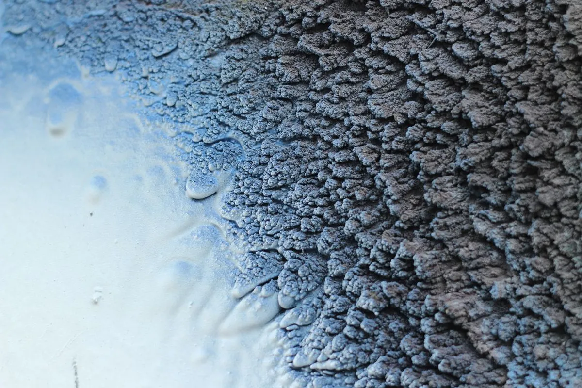 Cured foam in close view — the dense, sealed texture is the air barrier batts cannot make: Angi prices the material at $0.60–$1.60 per board foot open-cell and $1.30–$3.10 closed-cell