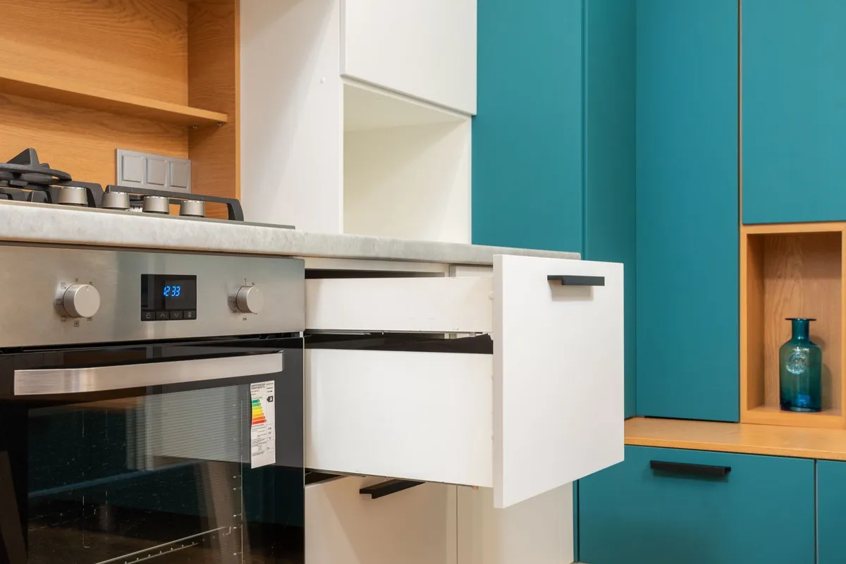 A stainless steel oven and hob set into a counter run in close view — steel is priced by gauge, and the appliances show the brushed finish most residential counters are ordered in.