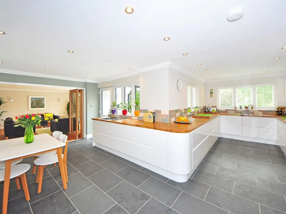 Large kitchen with white cabinets and a dark slate-look tile floor