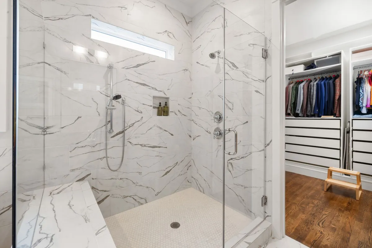 Inside the enclosure the money is the pan, the waterproofing and the tile: Angi prices shower pans at $900–$2,300 and labor at 40–60% of a shower installation