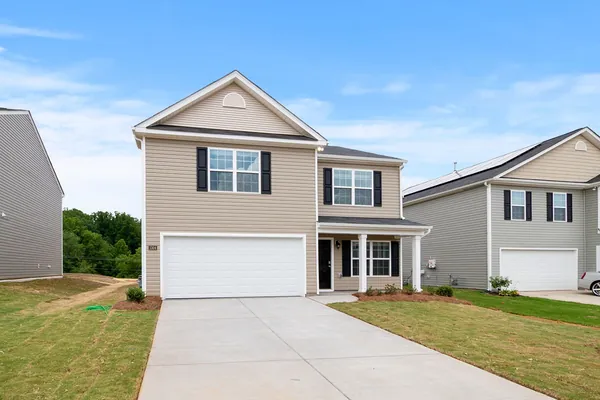 Two-story suburban home with a shingle roof, driveway and front lawn